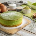 Freshly baked matcha sponge cake with bright green interior and matcha powder topping.